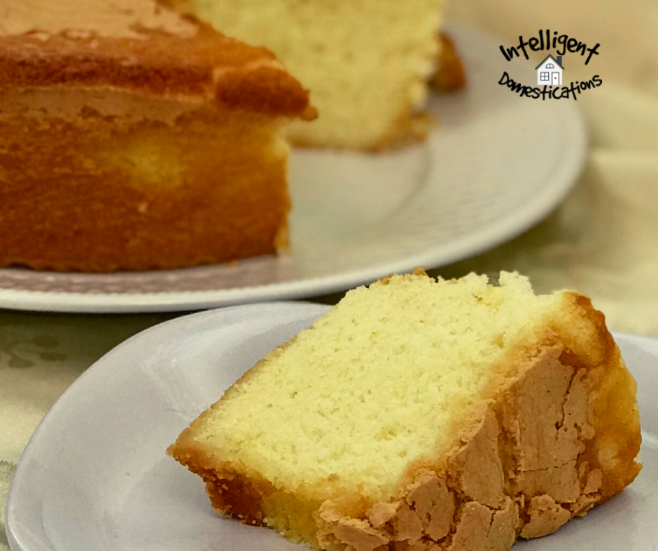 a slice of Pound cake on a white dish in front of the whole cake