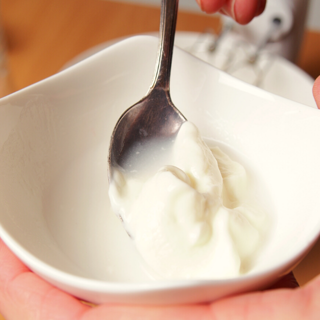 baking soda being dissolved into sour cream in a small white bowl using a spoon