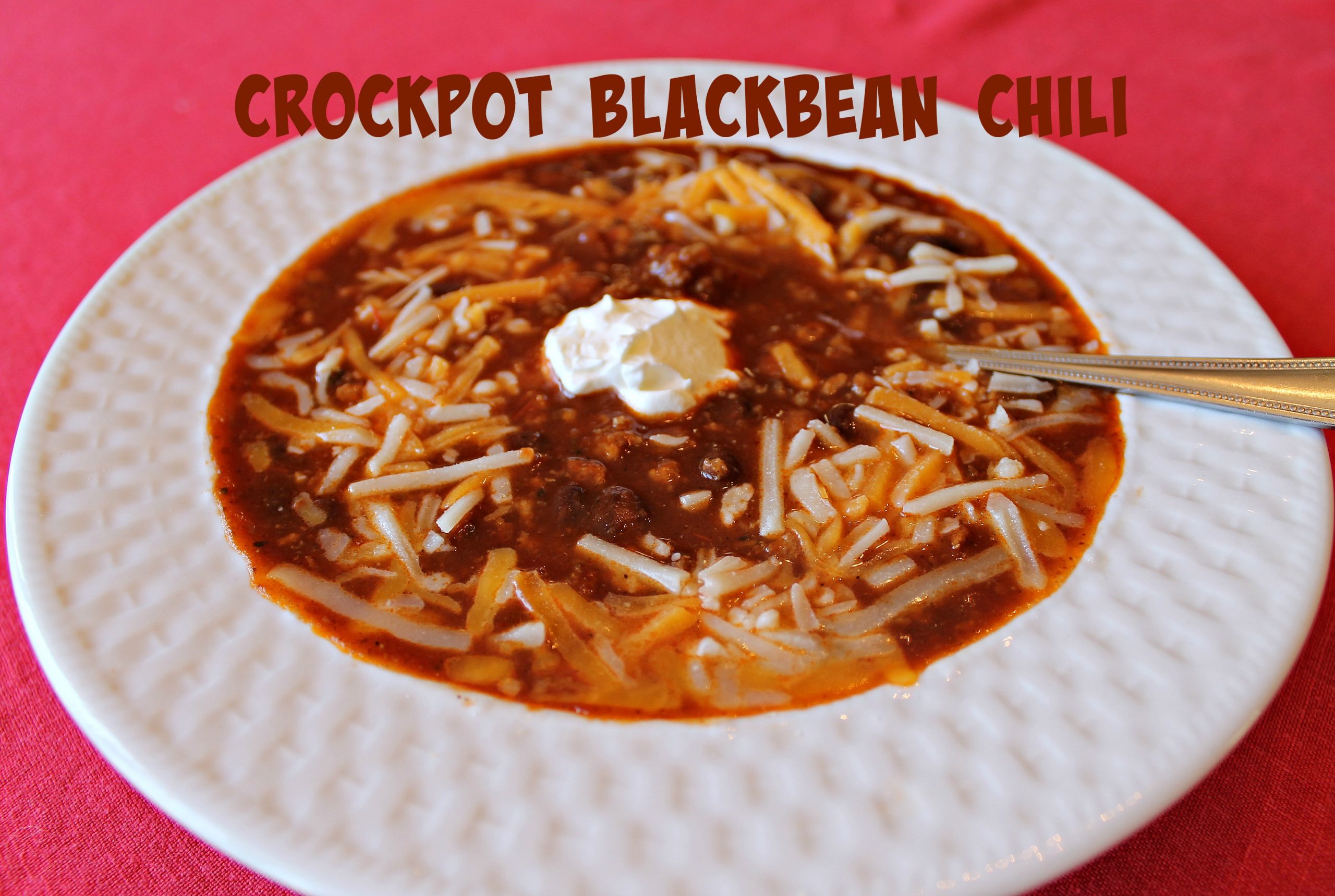 Enjoy a bowl of Crockpot Black Bean Chili topped with shredded cheese and sour cream. Recipe at www.intelligentdomestications.com