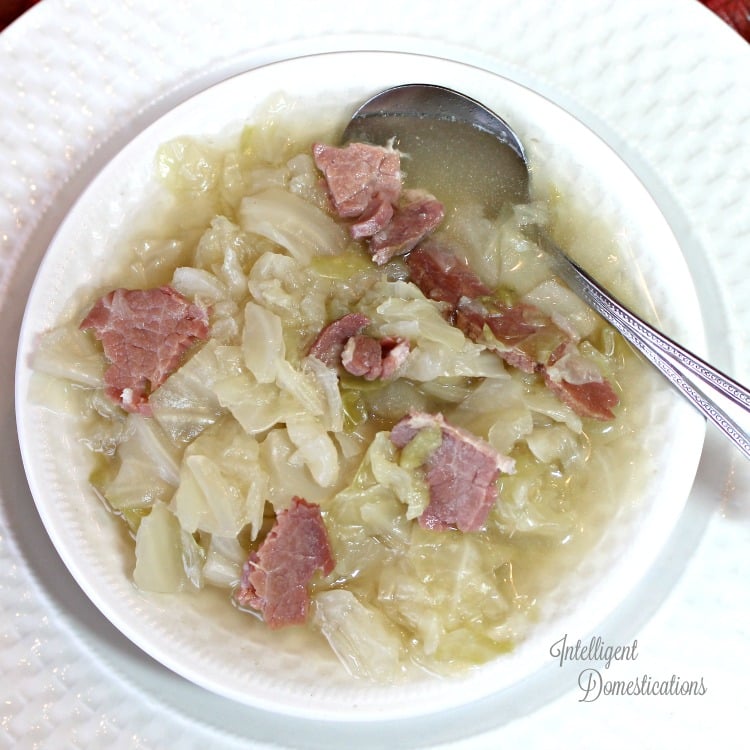 cabbage soup with ham in a white bowl