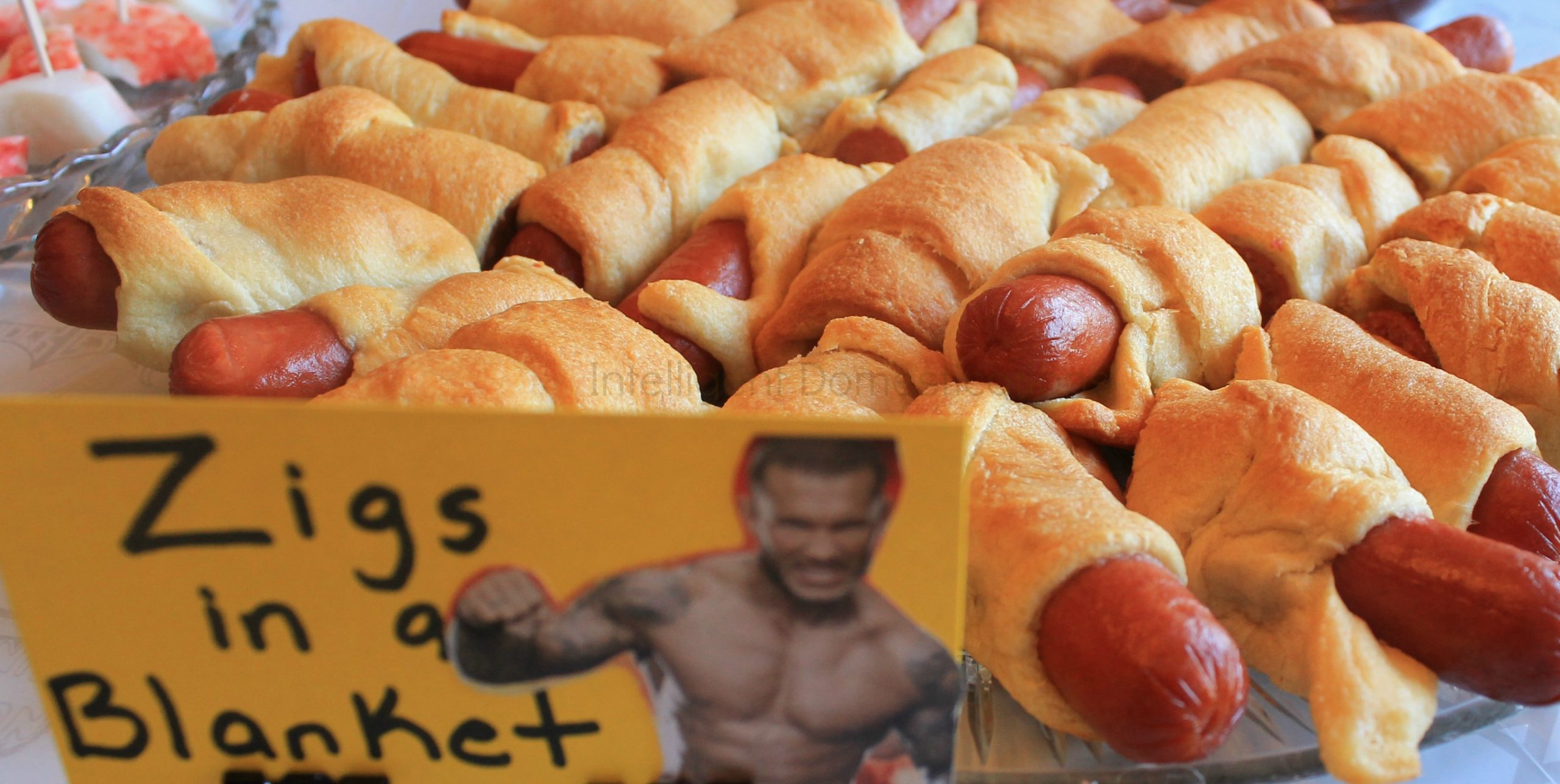 Planning a Wrestlemania party is always the most fun. With WWE Pun Named party food and drinks, we know the menu will be yummy. This is one of our Wrestlemania parties with all the food and decor ideas. #WWEparty WWE Theme Party Ideas with recipes and decor. WWE Party. Serve your guests some Zigs in a blanket at your WWE Theme party. Ideas at www.intelligentdomestications.com