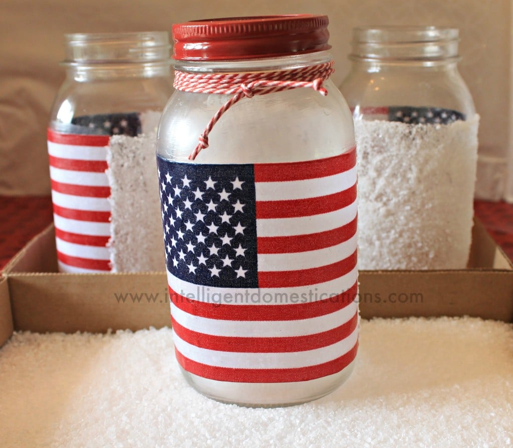 DIY Patrioric Mason Jar Luminaries. Patriotic Mason Jar Mod Podge craft project. How to make Patriotic Mason Jar Candle holders. #patrioticmasonjar #masonjarcraft #patrioticoutdoordecor #diypatrioticdecor