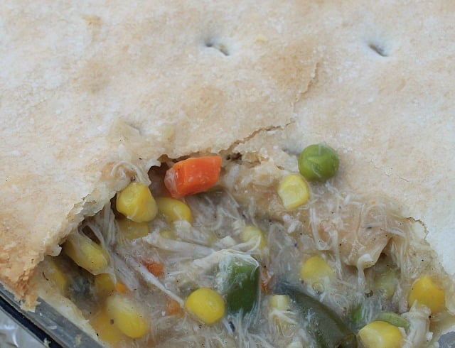 Homemade Chicken Pot Pie with top and bottom crusts. I like to cook the chicken from scratch for a delicious and packed with flavor Chicken Pot Pie. Only 8 ingredients. #Chickenrecipe #casserole chicken pot pie with a big scoop removed revealing the chicken and vegetables under the golden crust