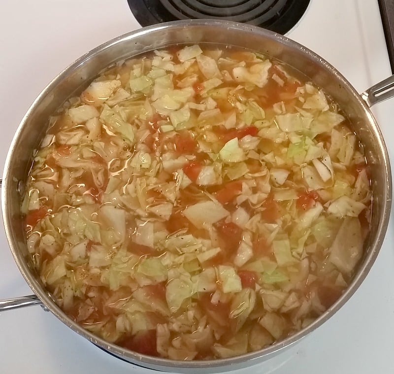 Skillet Cabbage, Rice and Sausage with tomatoes cooking on the stove.intelligentdomestications.com