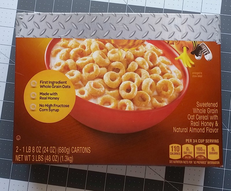 Cut a cereal box in half and begin wrapping it in Duct tape