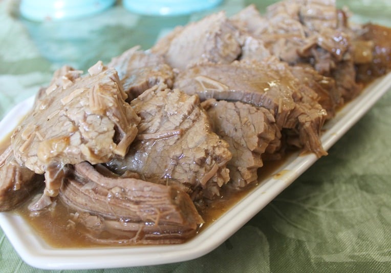 Top round roast and brown gravy sliced and served on a platter