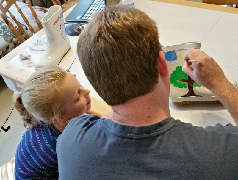 AShley watching Papa paint her new My Design Paintable Rain Boots