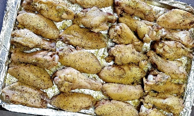 Lemon pepper wings on a baking pan ready to bake