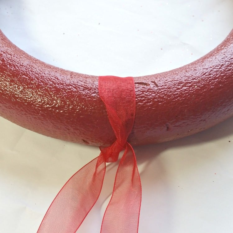 spray-paint-the-wreath-red-then-add-a-ribbon-for-hanging