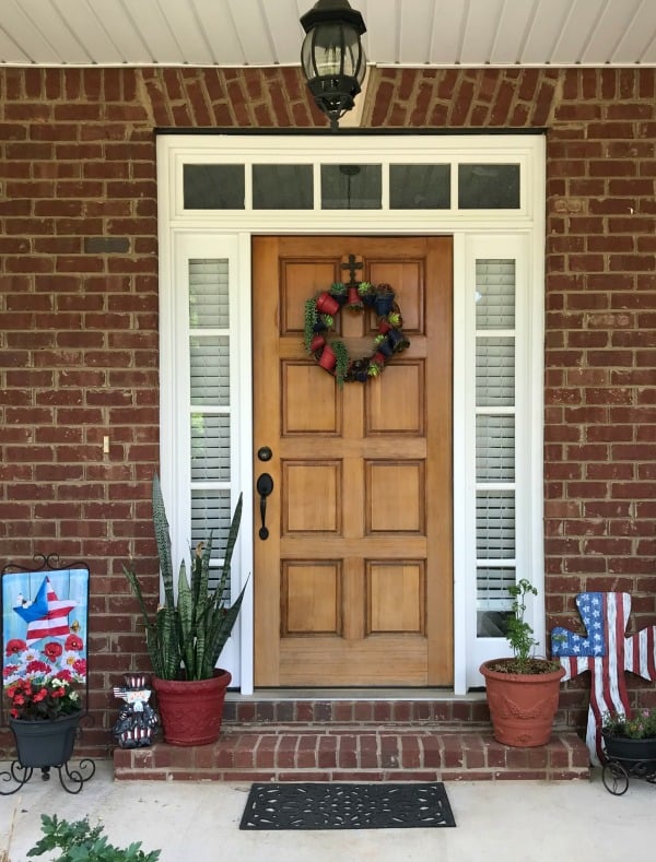 A flower pot wreath on a wooden front door