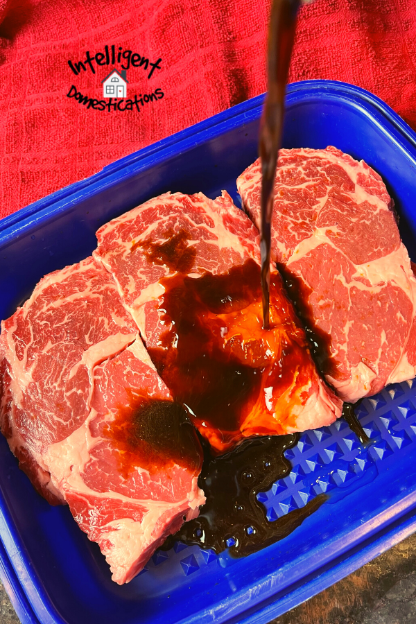 marinade being poured over steaks in a plastic container