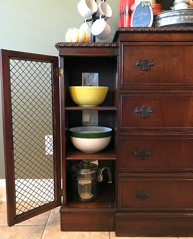 A peep inside an antique dining room sideboard filled with vintage bowls