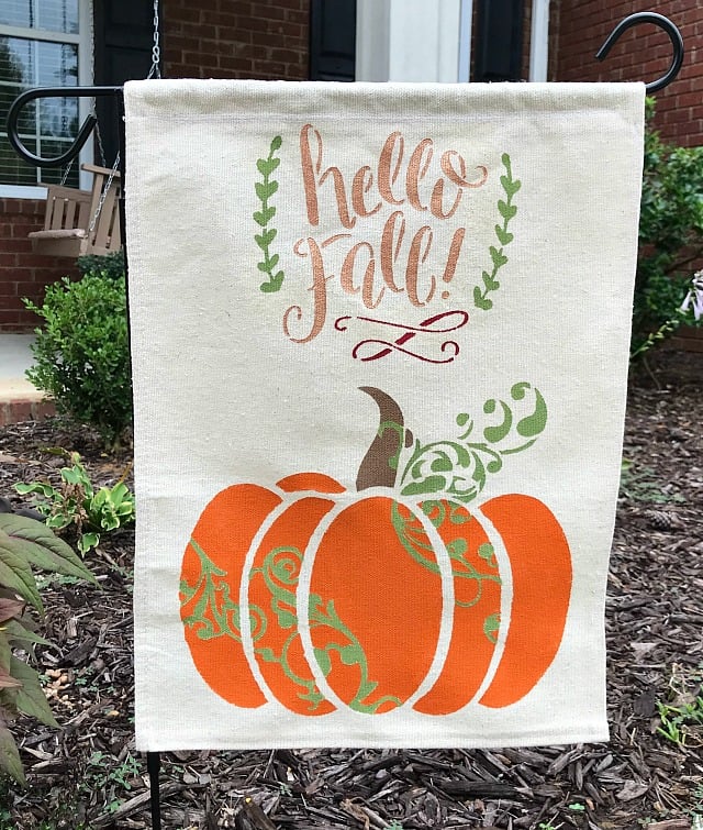 DIY Fall Garden Flag. This Tutorial includes how to make a garden flag using a drop cloth, stencils and paint. Quick and Easy DIY Fall Outdoor Decor project. #gardenflag #dropcloth #diy #falldecor #pumpkins #hellofall #fall #yardflag #autumn