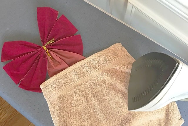an window wreath bow being pressed with an iron