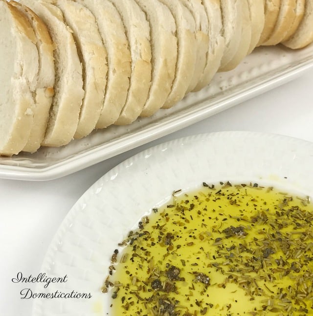 Easy Italian Butter recipe. Just like Carrabba's. Make your own Italian Olive Oil dip for bread using a few Italian herbs and spices. #italianbutter #copycatrecipe #Italiandinner Italian sliced bread and a bowl of Italian butter next to it