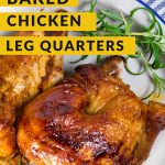 Baked Chicken Leg Quarters on a white plate next to a blue cloth napkin