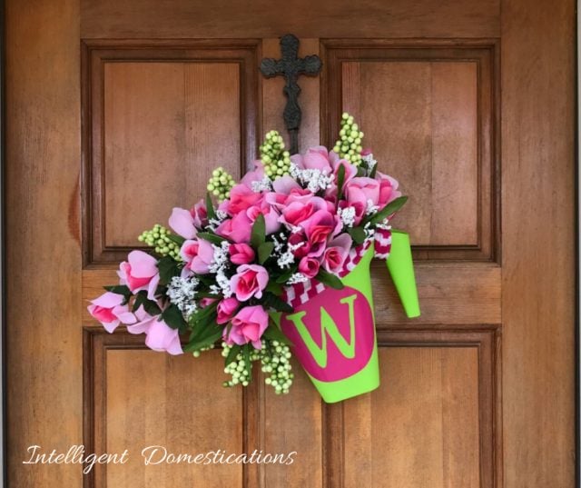 DIY Monogrammed Watering Can Wreath with bouquets of Roses spilling from the spout. I made this Spring wreath using Dollar Store supplies and my Cricut. It comes together in under one hour. Make this pretty Dollar store Spring Wreath for you home. #Wreath #diydecor