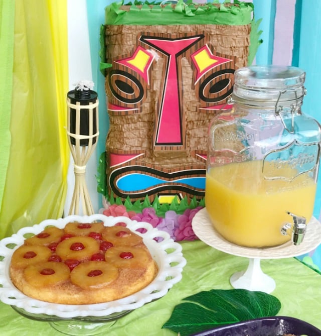 Luau party food table with Pineapple upside down cake and orange punch