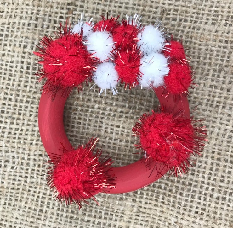 You can make this adorable Mini Pom Pom Wreath Ornament for your Christmas Tree. This is an easy and inexpensive Christmas craft using few supplies. #Christmascraft