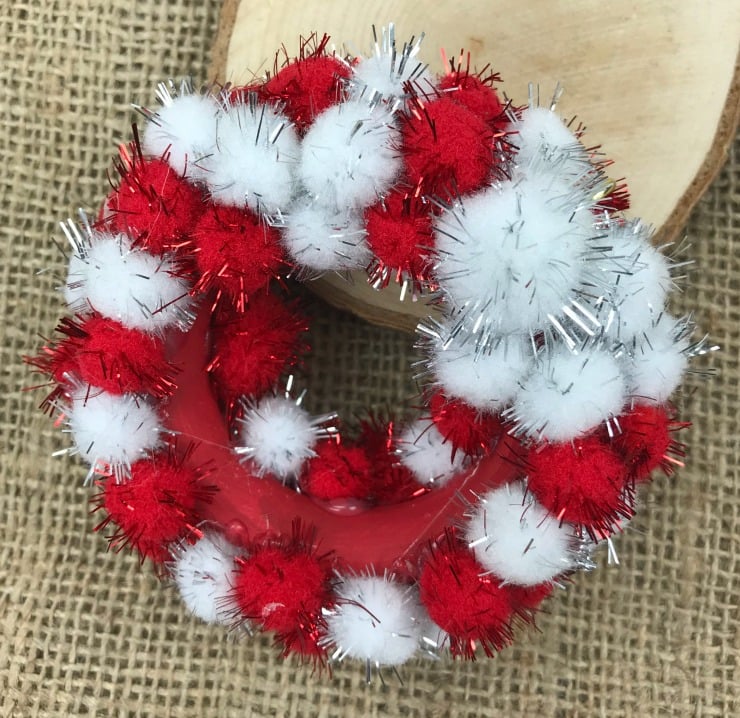 You can make this adorable Mini Pom Pom Wreath Ornament for your Christmas Tree. This is an easy and inexpensive Christmas craft using few supplies. #Christmascraft