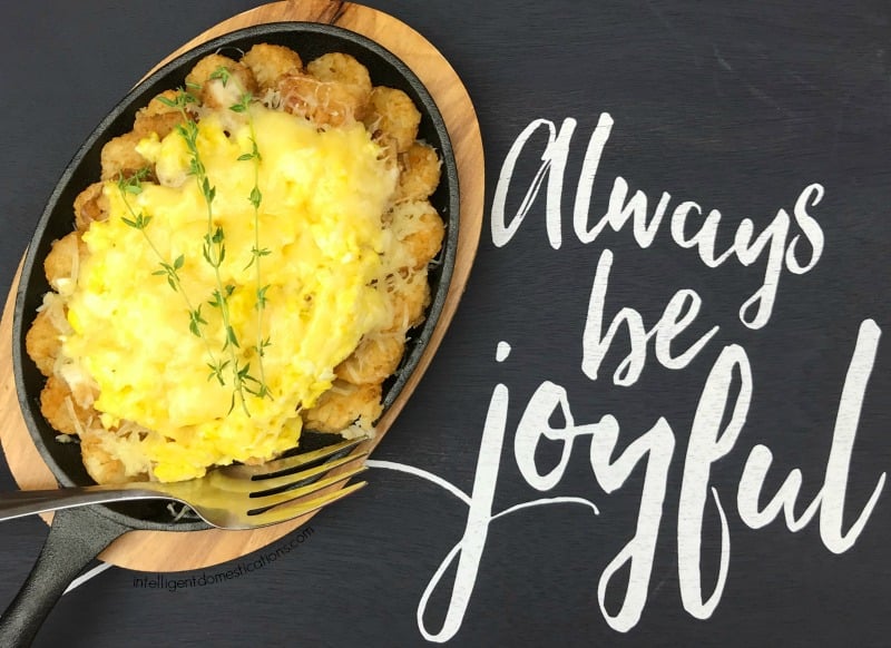 cheesey eggs on top of chicken tenders in a small skillet type dish with fresh thyme on top
