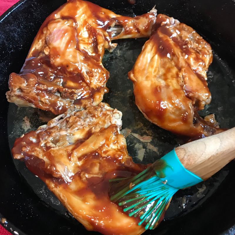 Turn the chicken over and baste with BBQ sauce