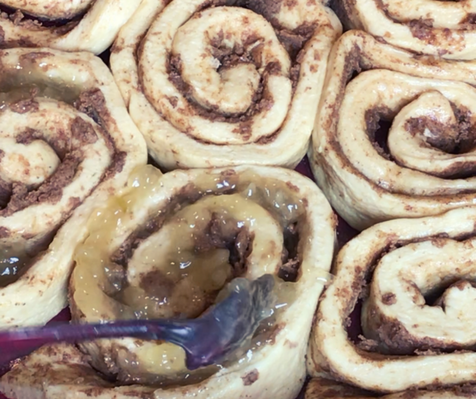 Cinnamon rolls being stuffed with apple filling