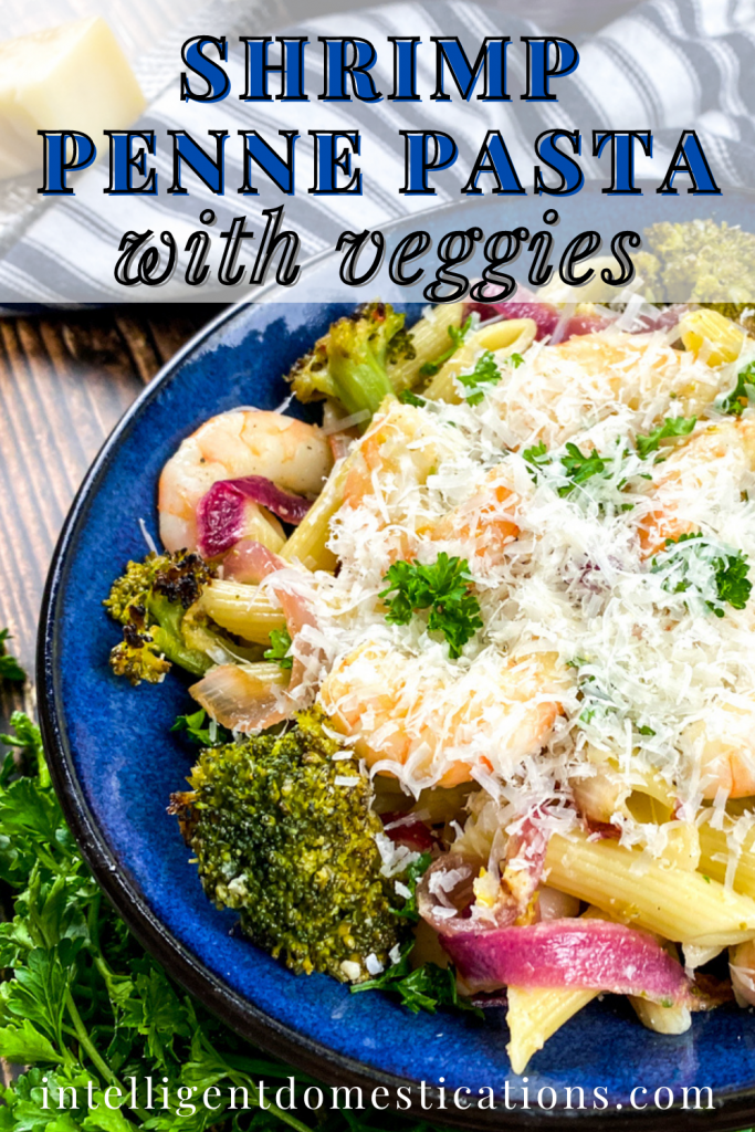 Shrimp pasta and broccoli in a blue bowl with parmesan cheese on top