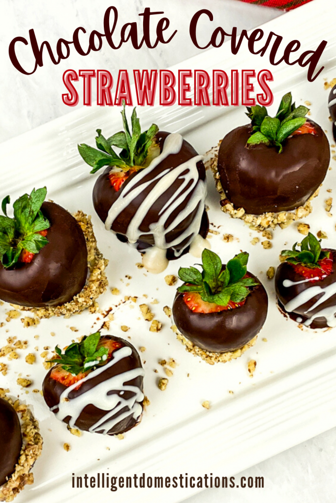 Chocolate covered strawberries on a white serving platter with pecans drizzled among them