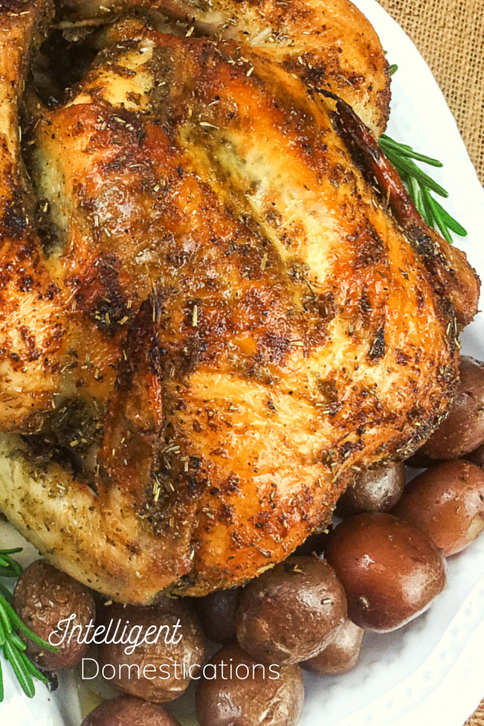 oven roasted chicken on a platter with small whole potatoes ready to eat
