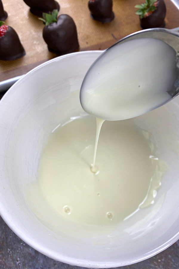 Melted white chocolate being drizzled from a spoon