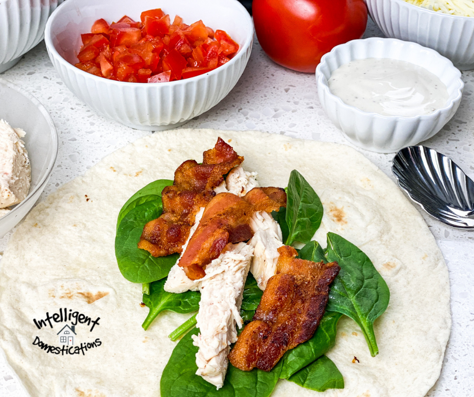 A chicken wrap with bacon in the process of being assembled