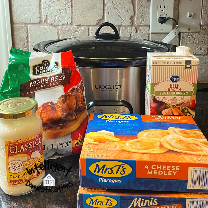frozen pierogi, alfredo sauce, frozen meatballs and beef broth sitting in front of a Crockpot