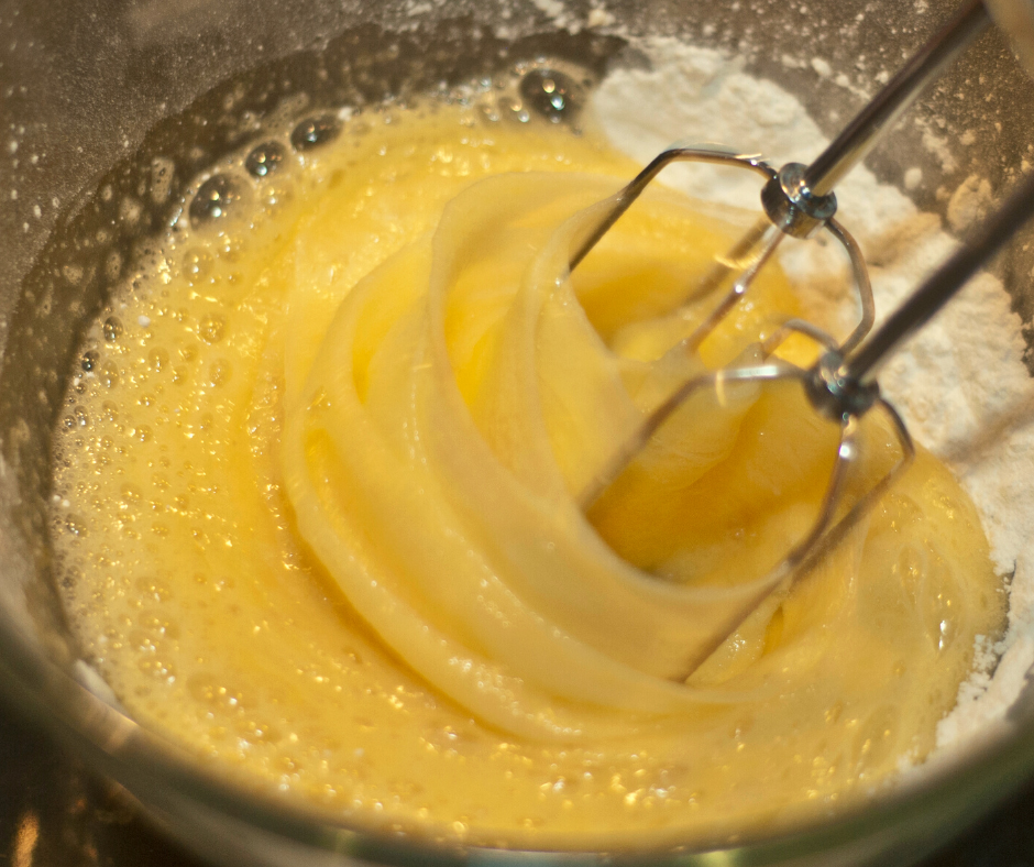 whipping eggs and sugar with an electric mixer