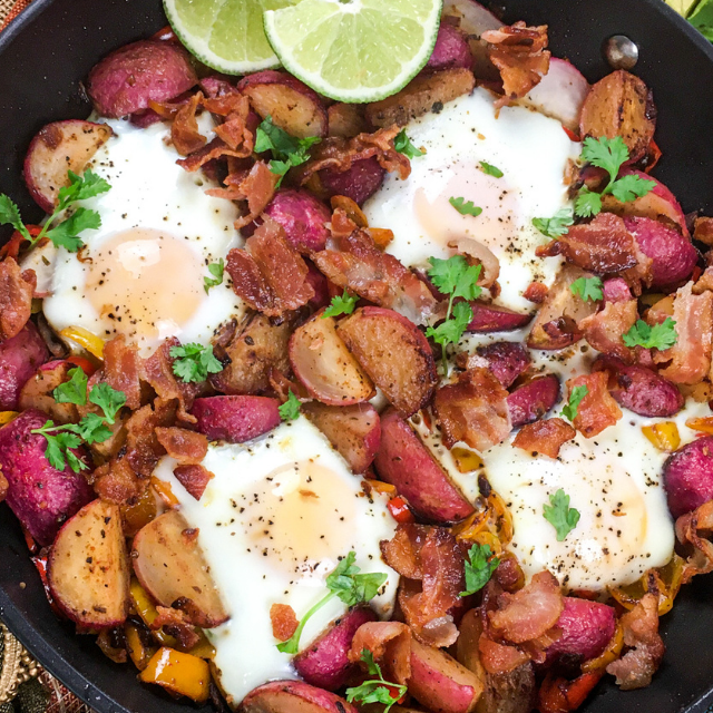 a breakfast skillet meal with eggs, bacon and vegetables