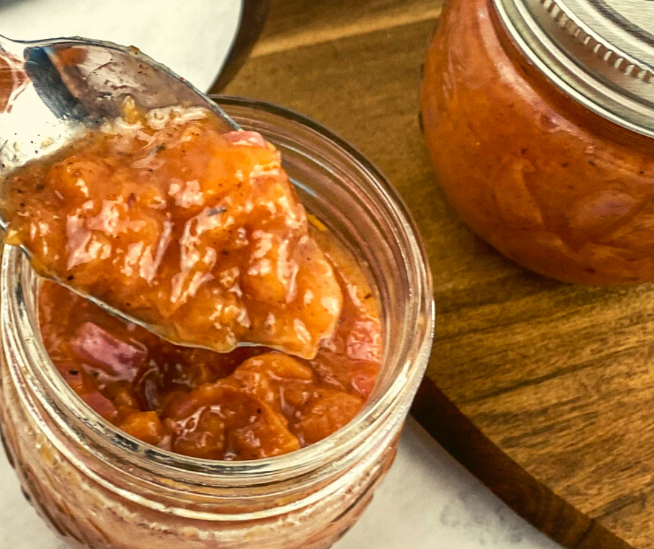 A close up of a spoon full of savory peach compote