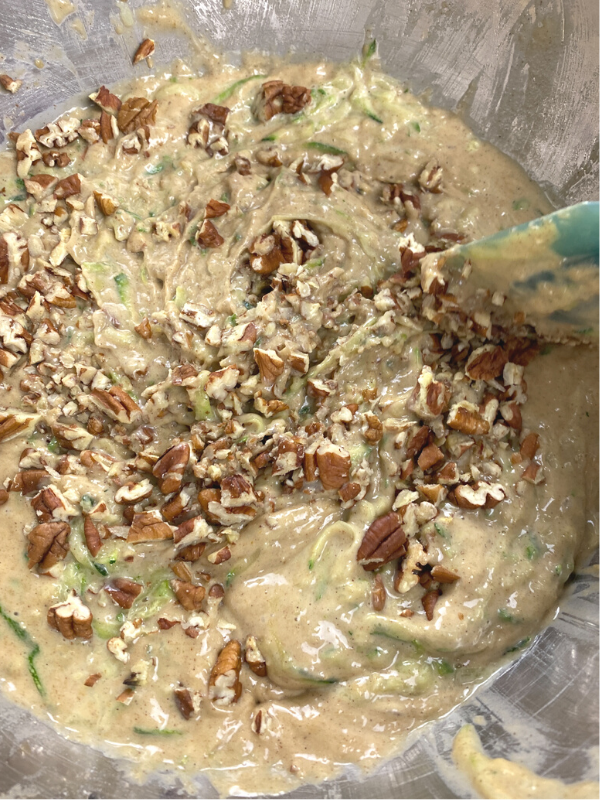 folding the zucchini and pecans into the mix with a spatula