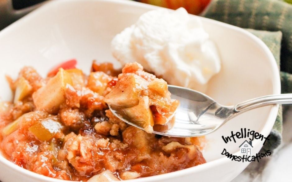 A bowl of Slow Cooker Apple Crisp with a dollop of vanilla ice cream