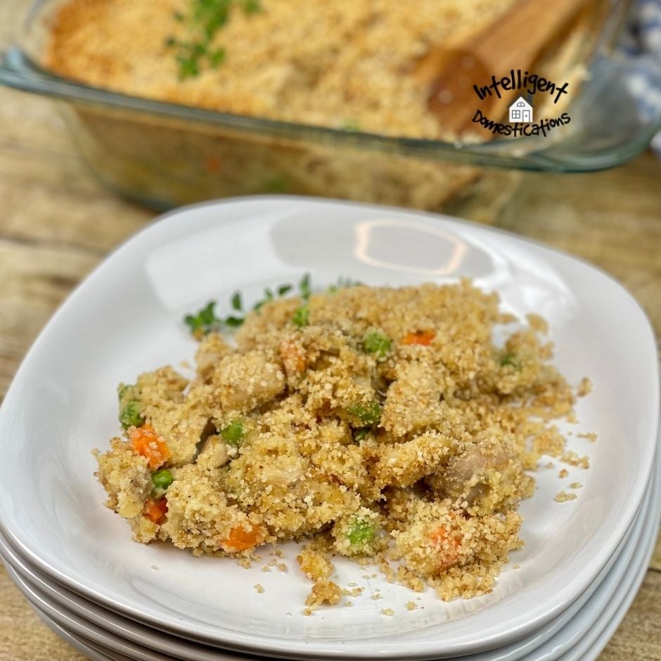 a Serving of Chicken Casserole on a white dish with the casserole in the background