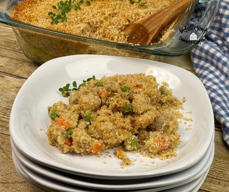 chicken and veggie casserole on a white dish in front of the casserole dish