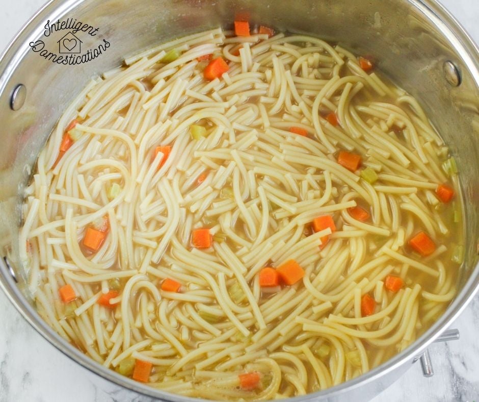 chicken noodle soup in a large pot cooking