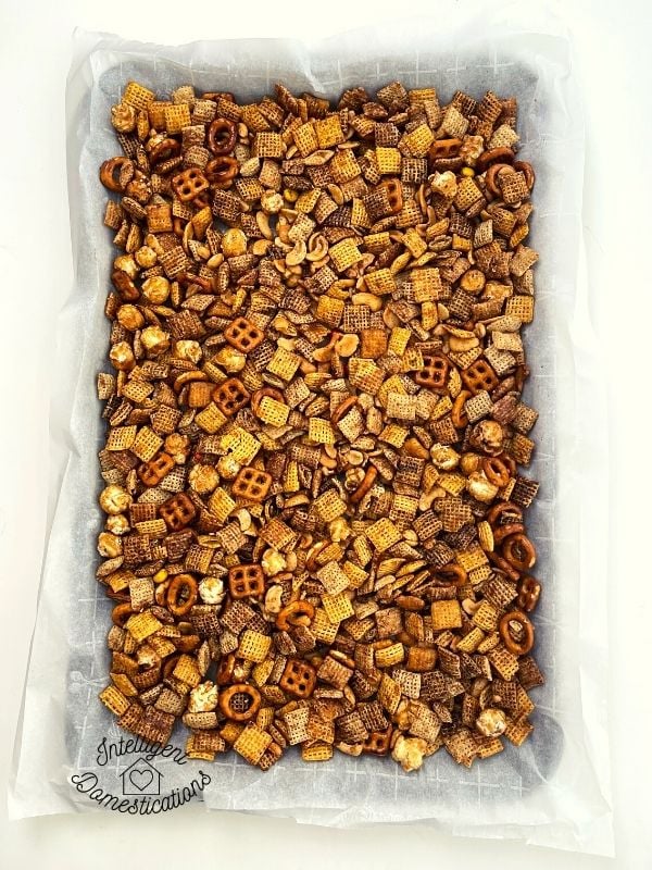 Pumpkin spice Chex mix on baking pan with parchment paper
