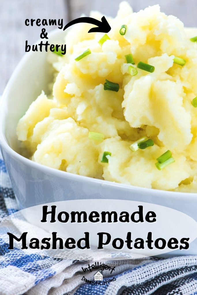 mashed potatoes in a white casserole dish with chives on top