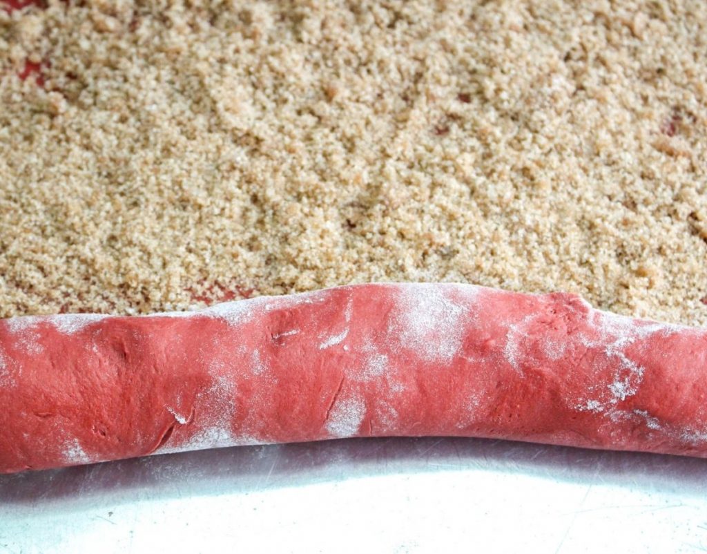 Rolling the cinnamon roll dough up jelly roll style