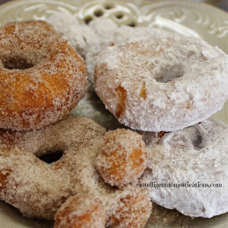 Biscuit donuts coated in powdered sugar and cinnamon sugar