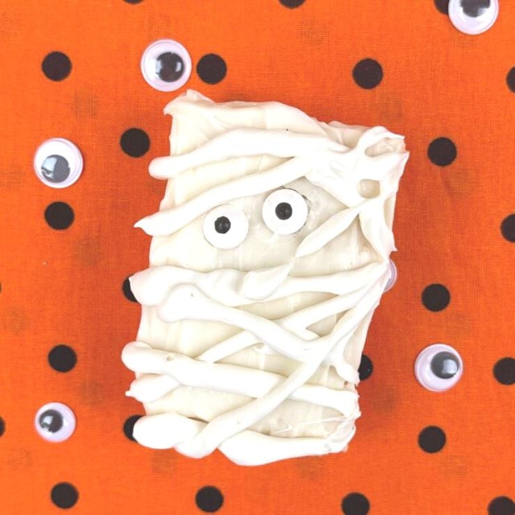One Mummy Rice Krispies Treat on an black and orange polka dot background