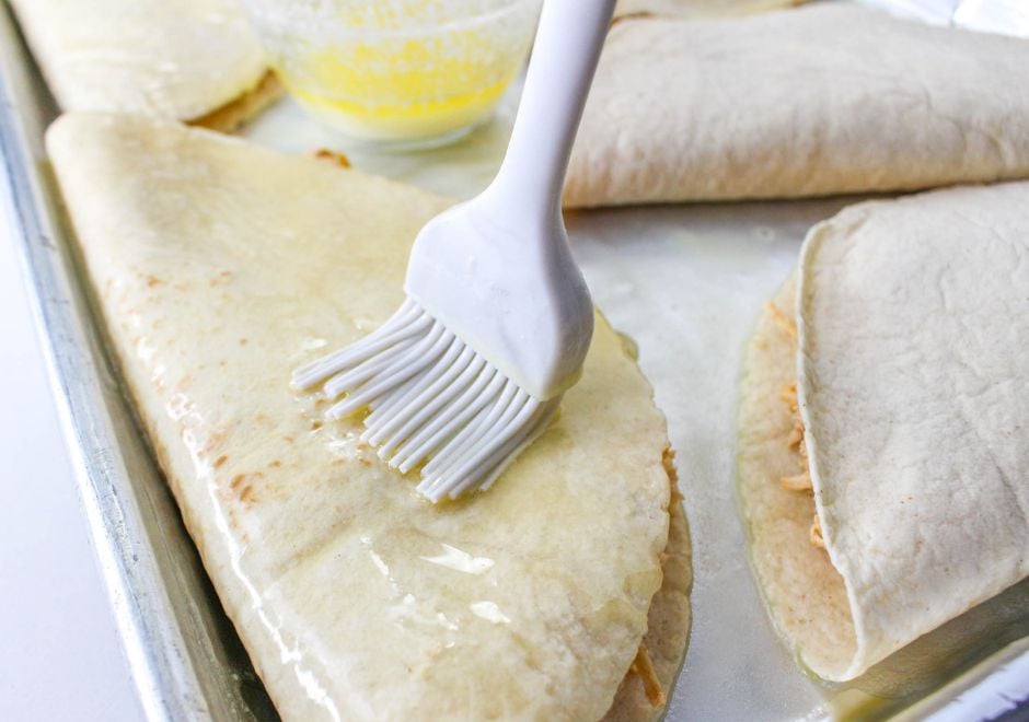 Brush melted butter onto the outside of the quesadilla tortilla