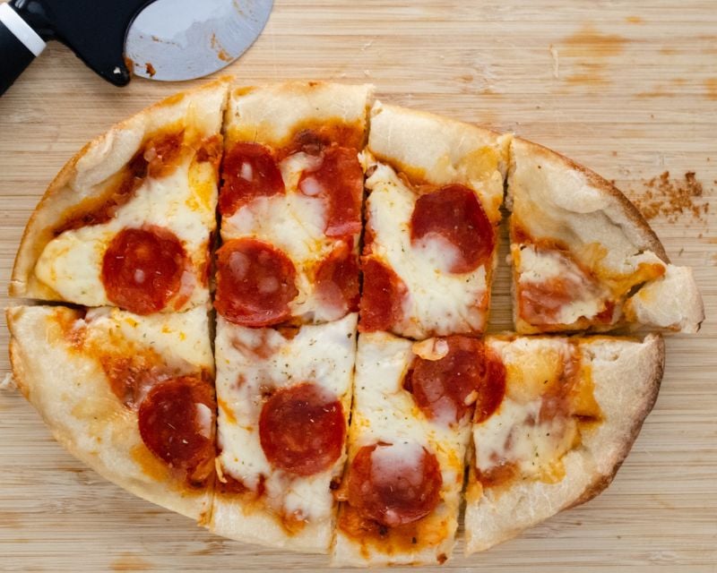 Homemade Pepperoni pizza sliced on a cutting board