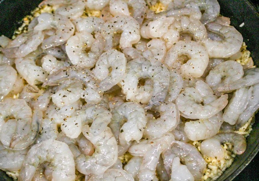 fresh shrimp on top of fried rice in a skillet