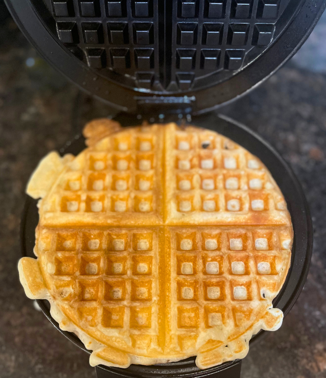 Golden brown waffle ready to come out of the waffle iron